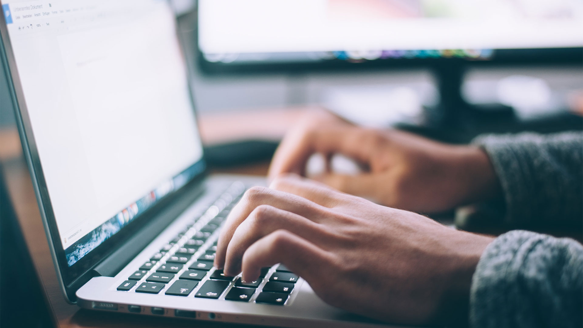 Image of a person's hands typing on a laptop